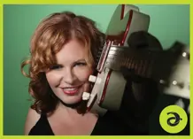 Closeup of Suzie Vinnick with a guitar on her shoulders