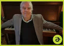 John Sheard in front of a piano