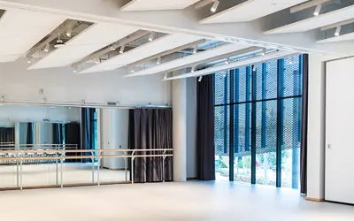 Inside of a dance studio, with dance bars and large windows