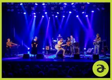 A band on a stage, with blue lighting