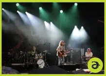 A band on stage with white and green lights over them