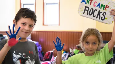 Two children showing painted hands